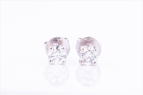 Lot 365 - A pair of solitaire diamond earrings the round...