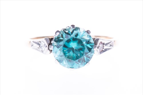 Lot 549 - A yellow metal, diamond, and blue zircon ring...