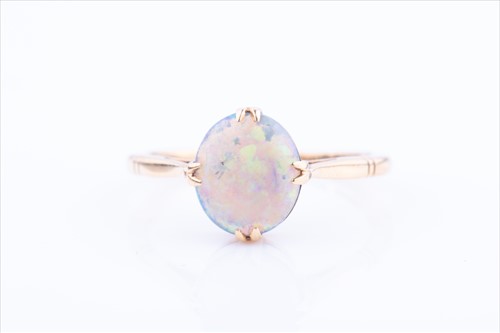 Lot 576 - An 18ct yellow gold and opal ring set with a...