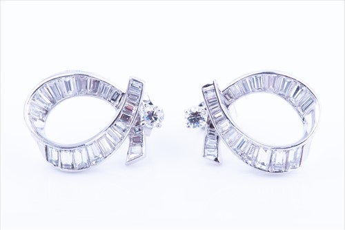 Lot 542 - A pair of ribbon-twist diamond earrings the...