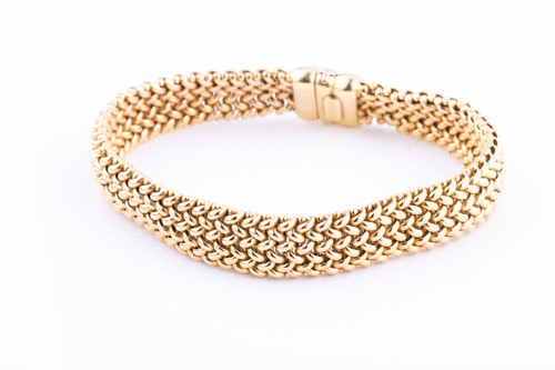Lot 476 - A yellow metal bracelet of articulated woven...