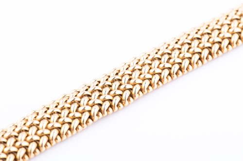 Lot 476 - A yellow metal bracelet of articulated woven...