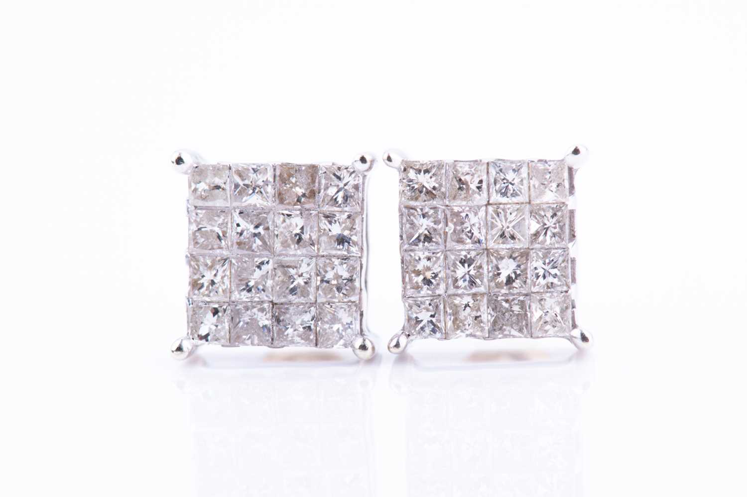 Lot 447 - A pair of white metal and diamond earrings of...