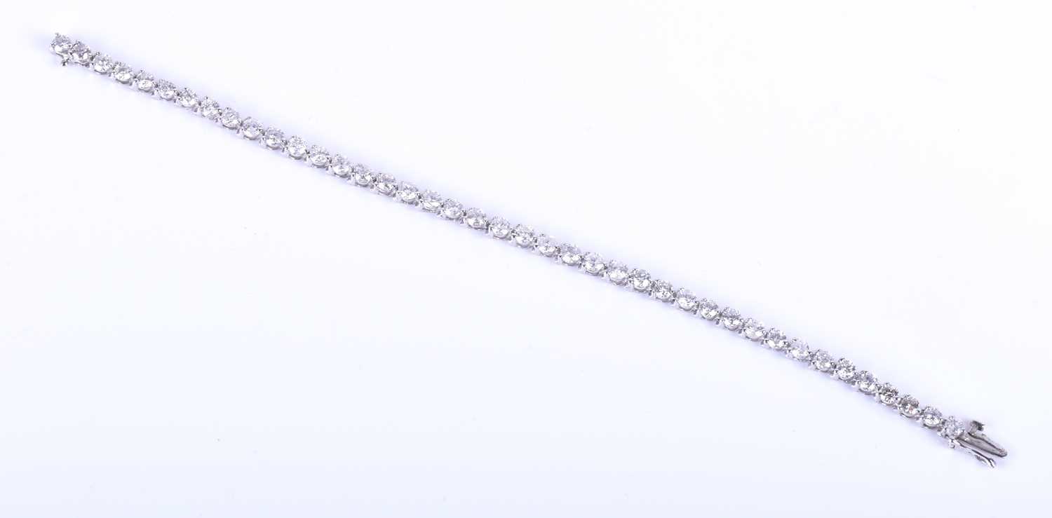 Lot 396 - A 14k white gold and diamond line bracelet,...