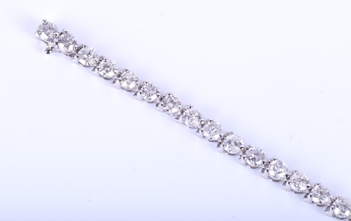Lot 396 - A 14k white gold and diamond line bracelet,...