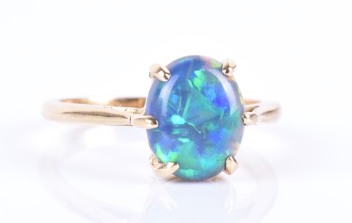 Lot 13 - An 18ct yellow gold and opal ring set with an...