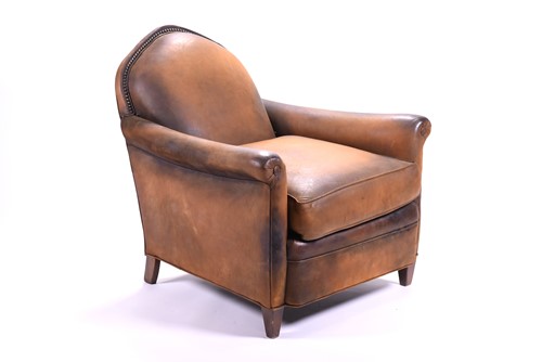 Lot 527 - A tan leather club armchair with padded seat...