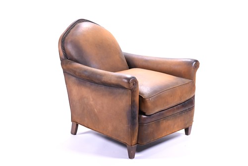 Lot 527 - A tan leather club armchair with padded seat...
