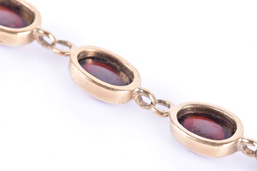 Lot 76 - A yellow metal and garnet bracelet set with...