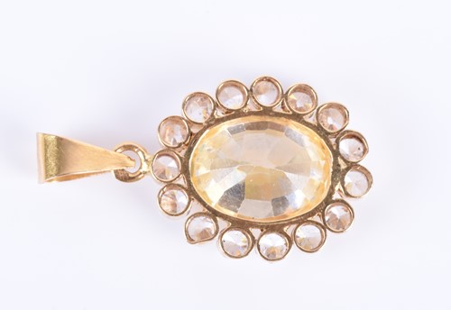 Lot 79 - A synthetic yellow sapphire pendant set with a...