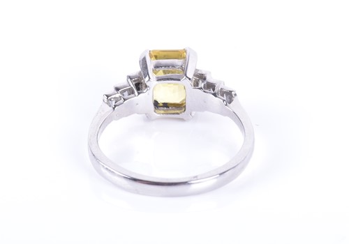 Lot 127 - A diamond and yellow sapphire ring centred...
