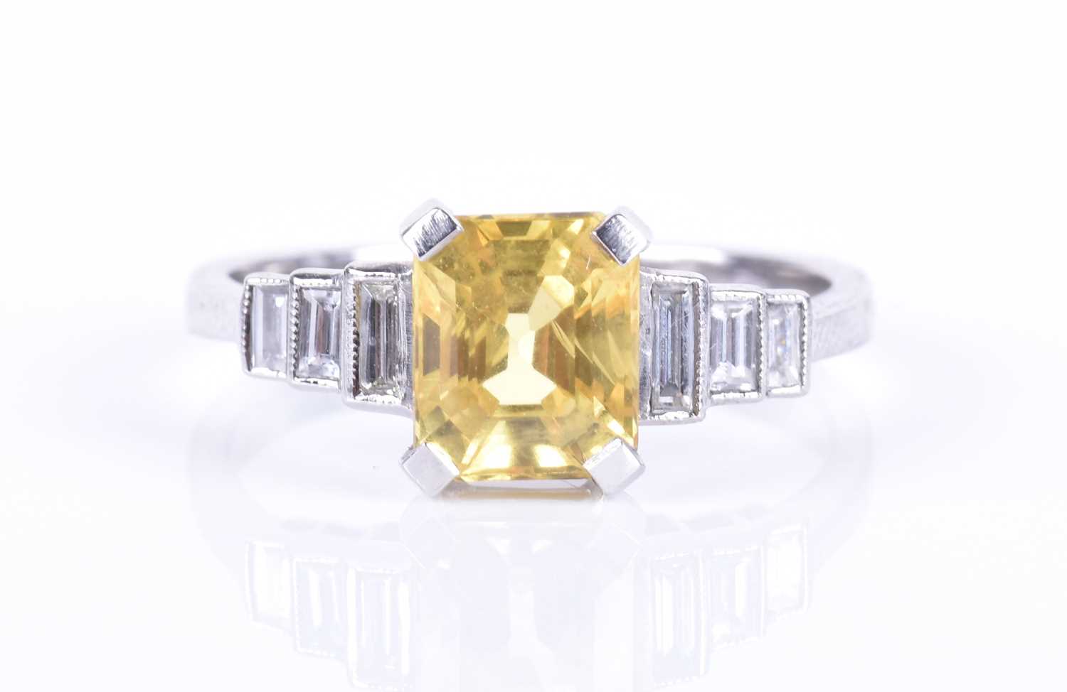 Lot 127 - A diamond and yellow sapphire ring centred...