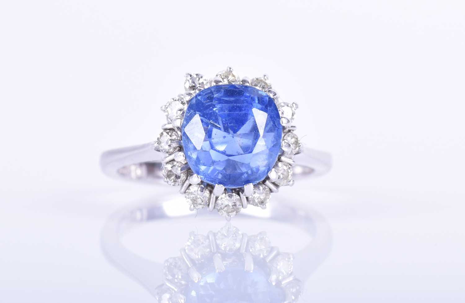 Lot 135 - An 18ct white gold, diamond, and blue sapphire...