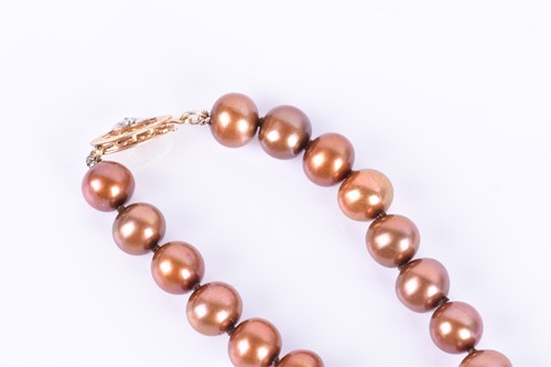 Lot 186 - A light brown pearl necklace 42 cm long,...