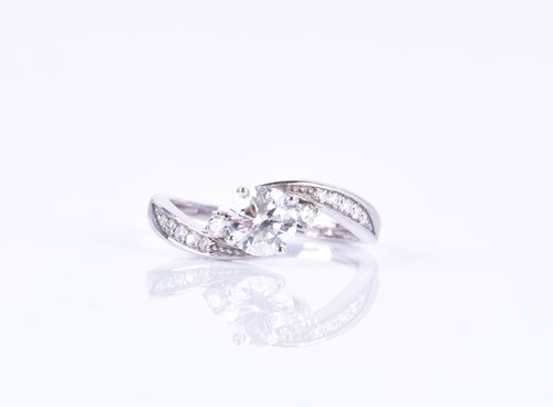 Lot 623 - A 14ct white gold and diamond ring, centered...