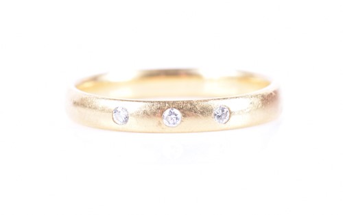 Lot 335 - An 18ct yellow gold and diamond band ring the...