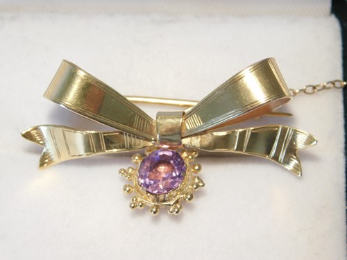 Lot 350 - A 9ct gold bow brooch with amethyst pendant...