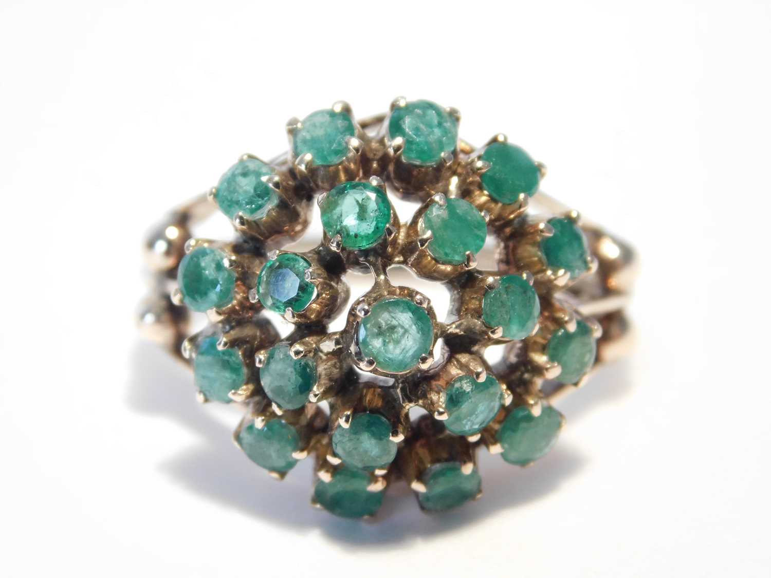 Lot 355 - An 18ct rose gold emerald cluster ring, the...