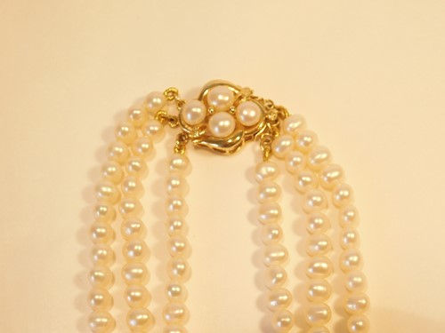 Lot 357 - A three strand pearl choker necklace, with...