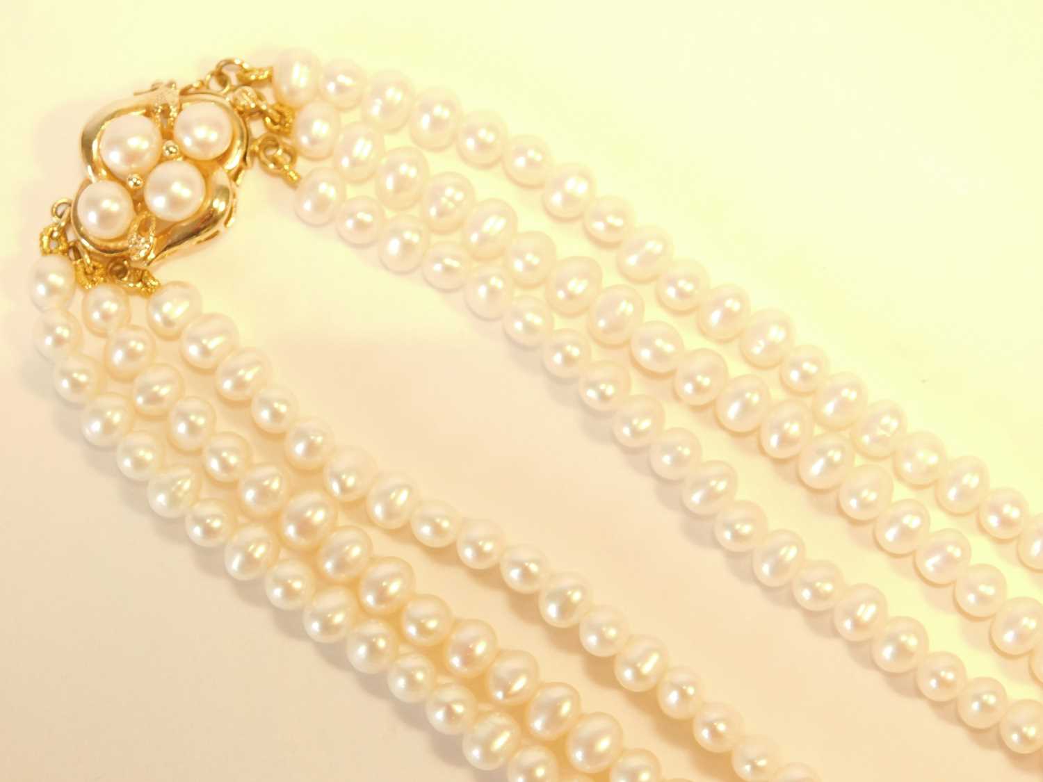 Lot 357 - A three strand pearl choker necklace, with...