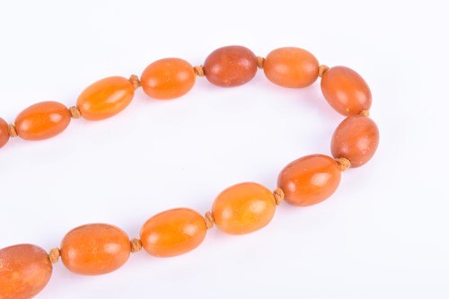 Lot 853 - A butterscotch amber necklace largest bead 2 x...