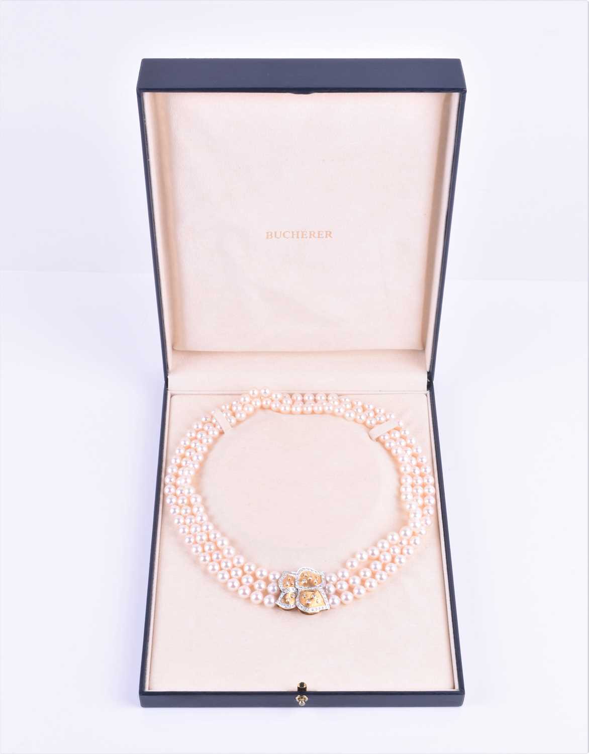 Lot 690 - A Bucherer Akoya triple strand pearl necklace,...