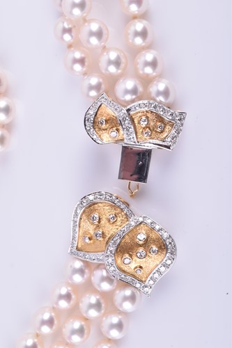 Lot 690 - A Bucherer Akoya triple strand pearl necklace,...