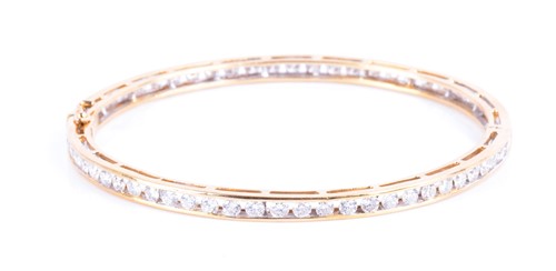 Lot 710 - A yellow metal and diamond bangle the bracelet...