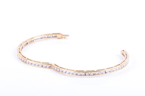 Lot 710 - A yellow metal and diamond bangle the bracelet...