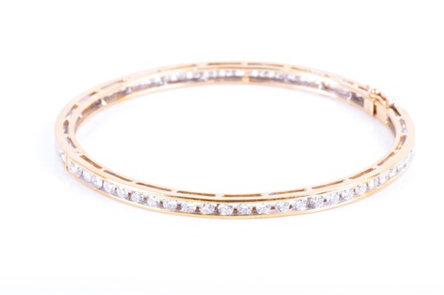 Lot 710 - A yellow metal and diamond bangle the bracelet...