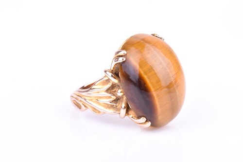 Lot 657 - A 9ct yellow gold and tigers eye ring set with...