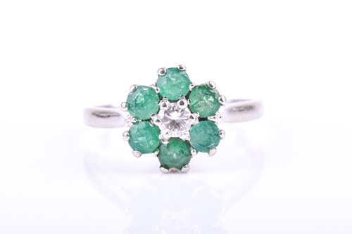 Lot 613 - An 18ct white gold, diamond, and emerald daisy...