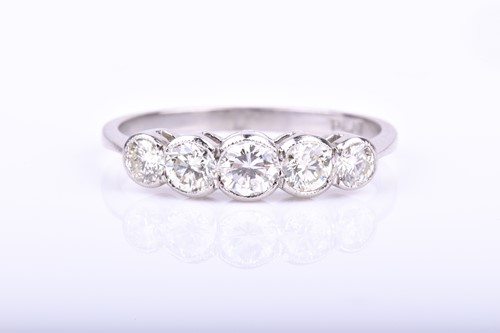 Lot 795 - A platinum and diamond ring millegrain set...