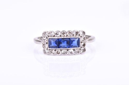 Lot 543 - An 18ct white gold, diamond, and sapphire ring...