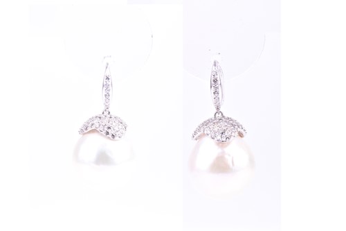 Lot 579 - A pair of silver and pearl drop earrings, the...