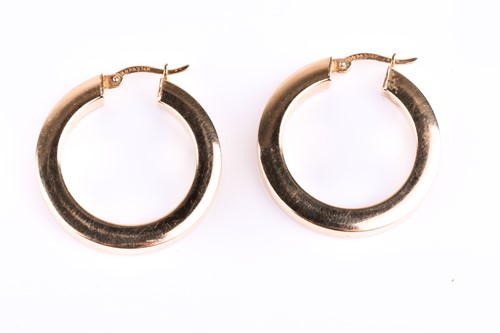 Lot 829 - A pair of yellow metal hoop earrings, of...