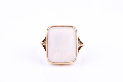 Lot 616 - A yellow metal and opal ring, set with a bezel-...