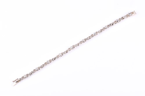 Lot 564 - A white metal and diamond bracelet, set with...