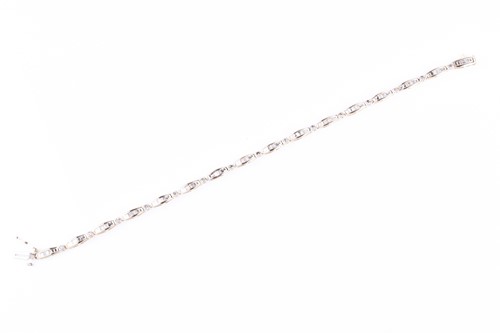 Lot 663 - A 14ct yellow gold and diamond line bracelet,...