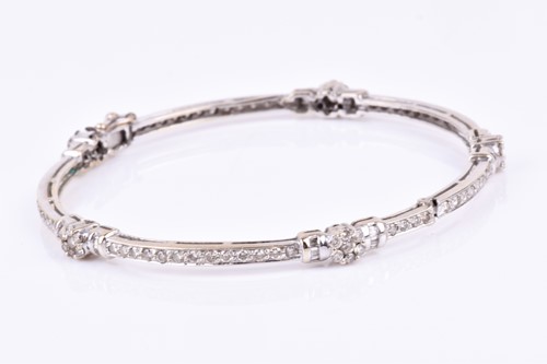 Lot 633 - A diamond bangle, the mount interspersed with...