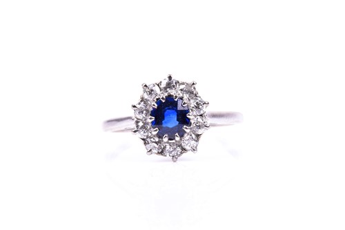 Lot 753 - A diamond and sapphire cluster ring, the mixed...