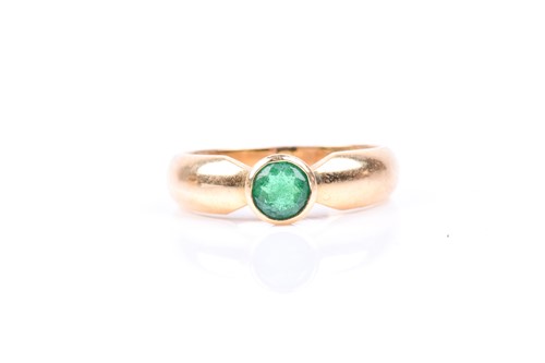 Lot 630 - An 18ct yellow gold and emerald ring, bezel...