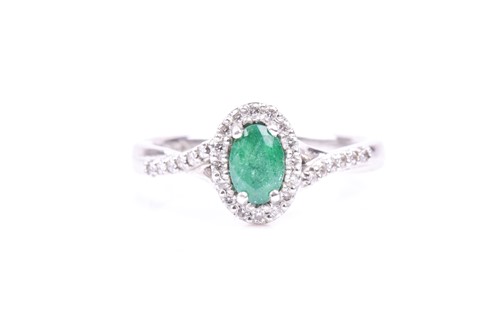 Lot 576 - A platinum, diamond, and emerald cluster ring,...