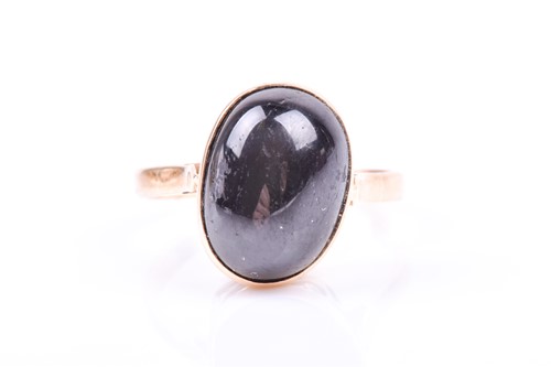 Lot 807 - A yellow metal and black chrysoberyl ring, the...