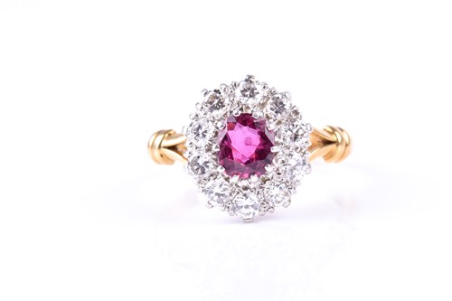 Lot 660 - A ruby and diamond cluster ring, the oval cut...