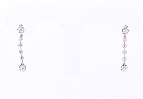 Lot 810 - A pair of diamond pendant earrings, the six...