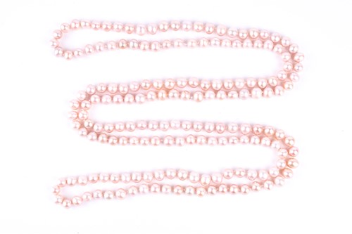 Lot 792 - An opera length pale pink pearl necklace, the...