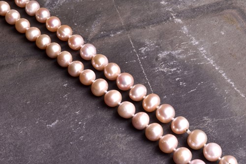 Lot 792 - An opera length pale pink pearl necklace, the...