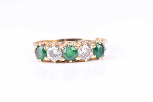 Lot 800 - A five stone half hoop emerald and diamond...