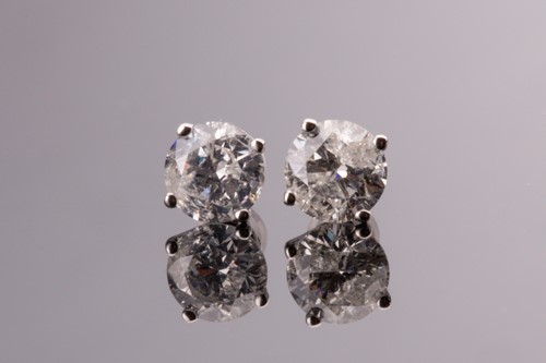 Lot 695 - A pair of solitaire diamond earrings, the...